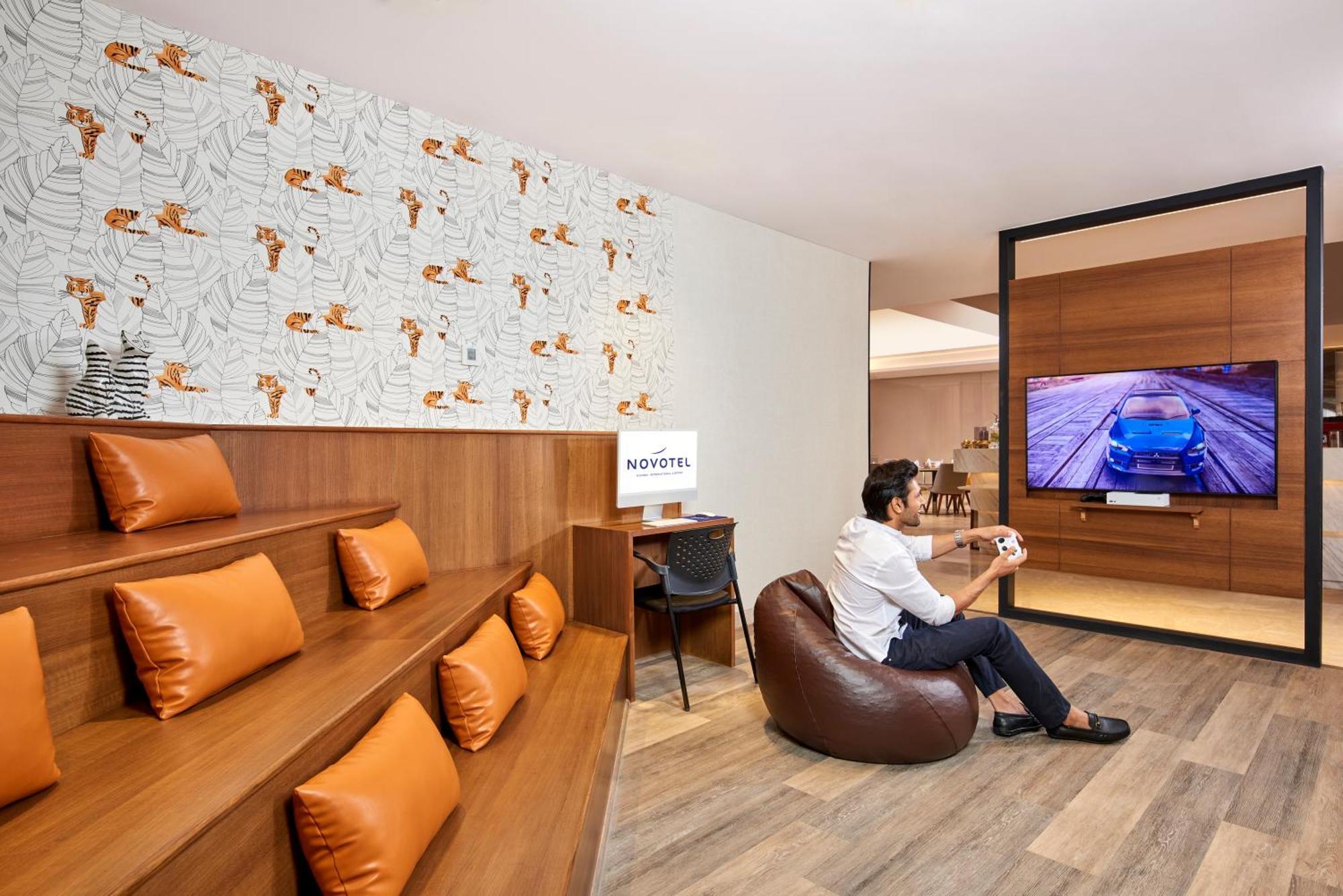Novotel Mumbai International Airport 외부 사진 A man playing a video game at the lounge